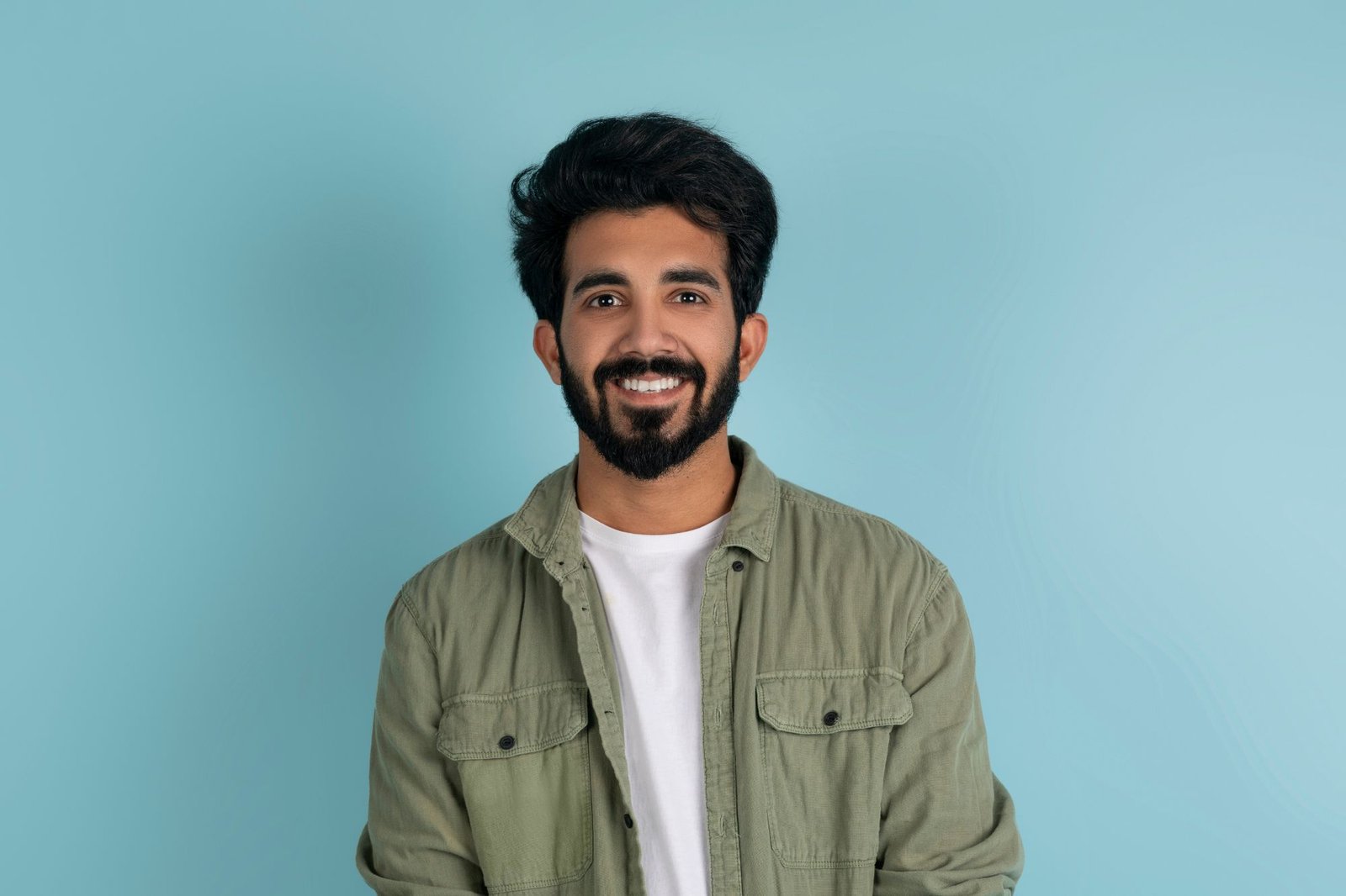 cheerful millennial indian guy in casual posing on nbyuuxd.jpg